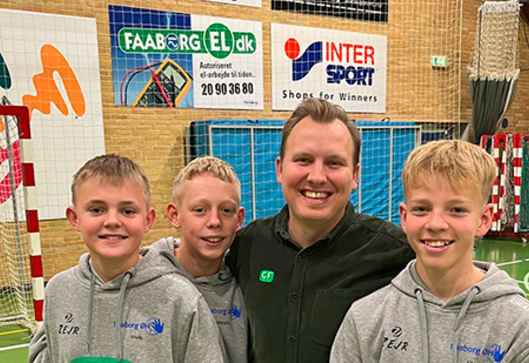 Unge drenge og træner i håndboldhal