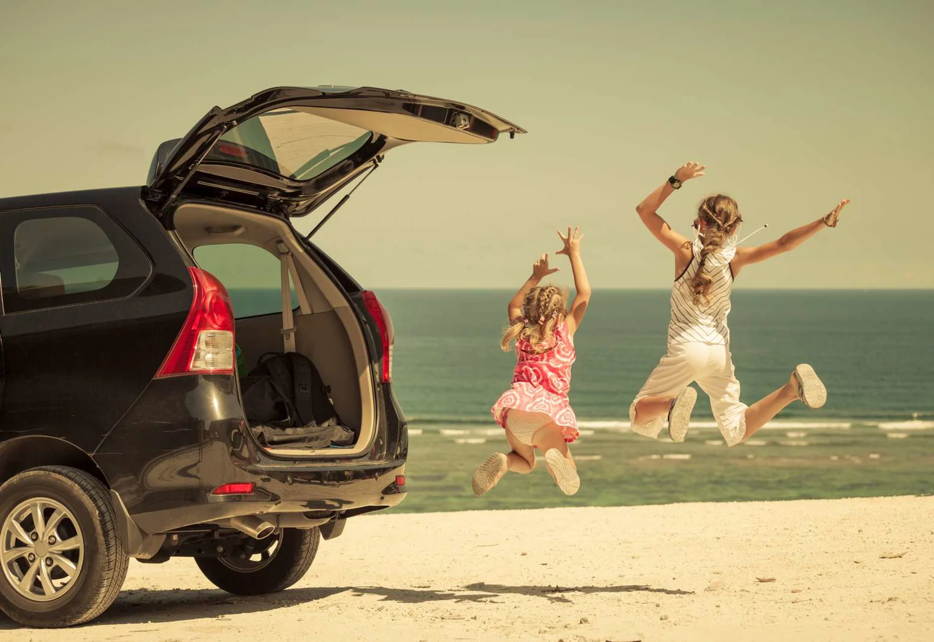 To piger som hopper ved stranden