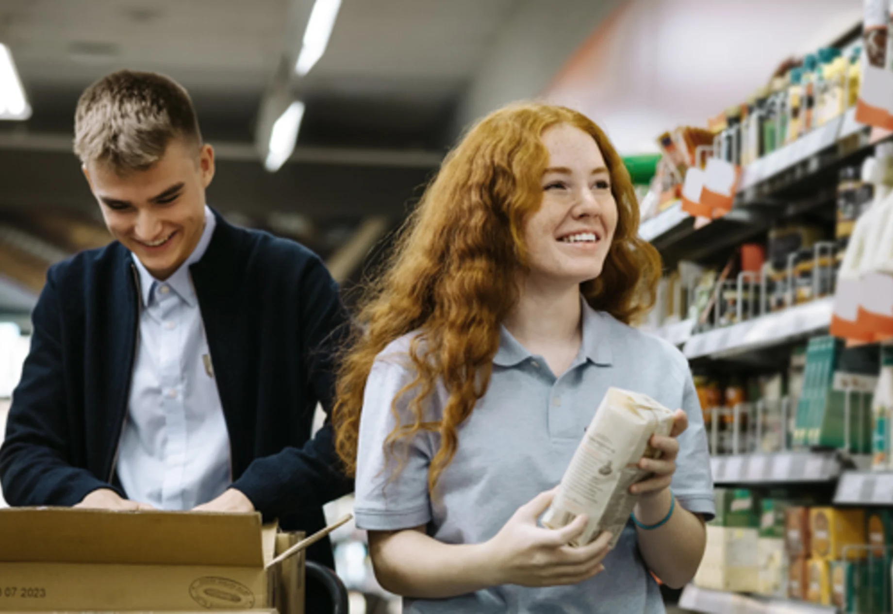Et billede som vider en pige og dreng som arbejder i et supermarked