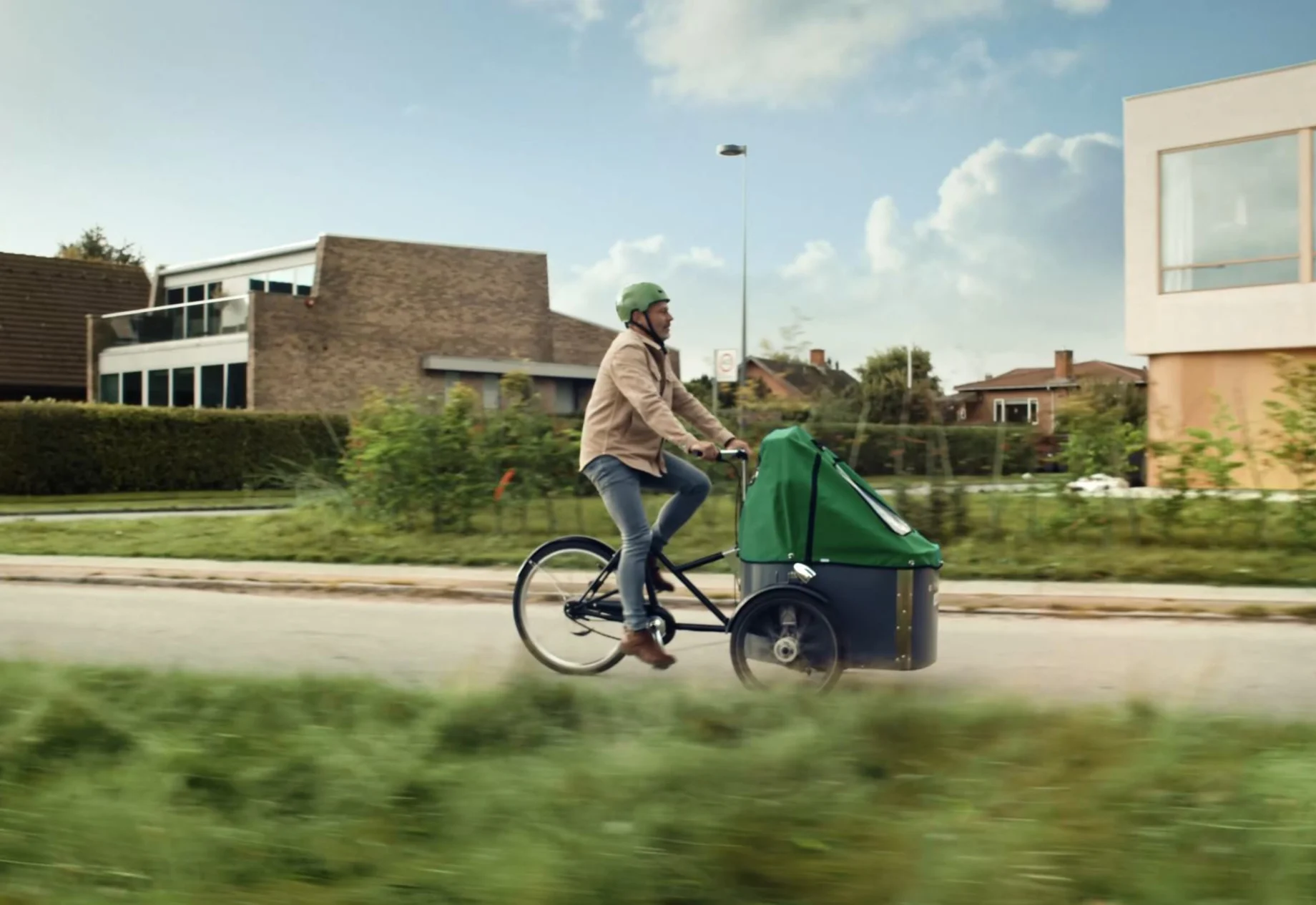Mand som cykler på en ladcykel