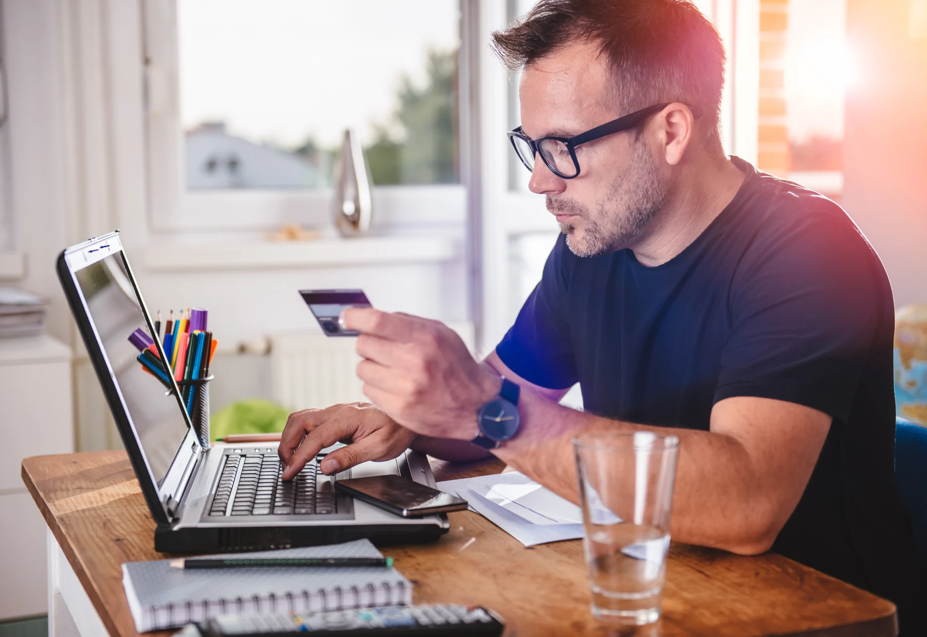 Mand som taster sine kortoplysninger ind på computer