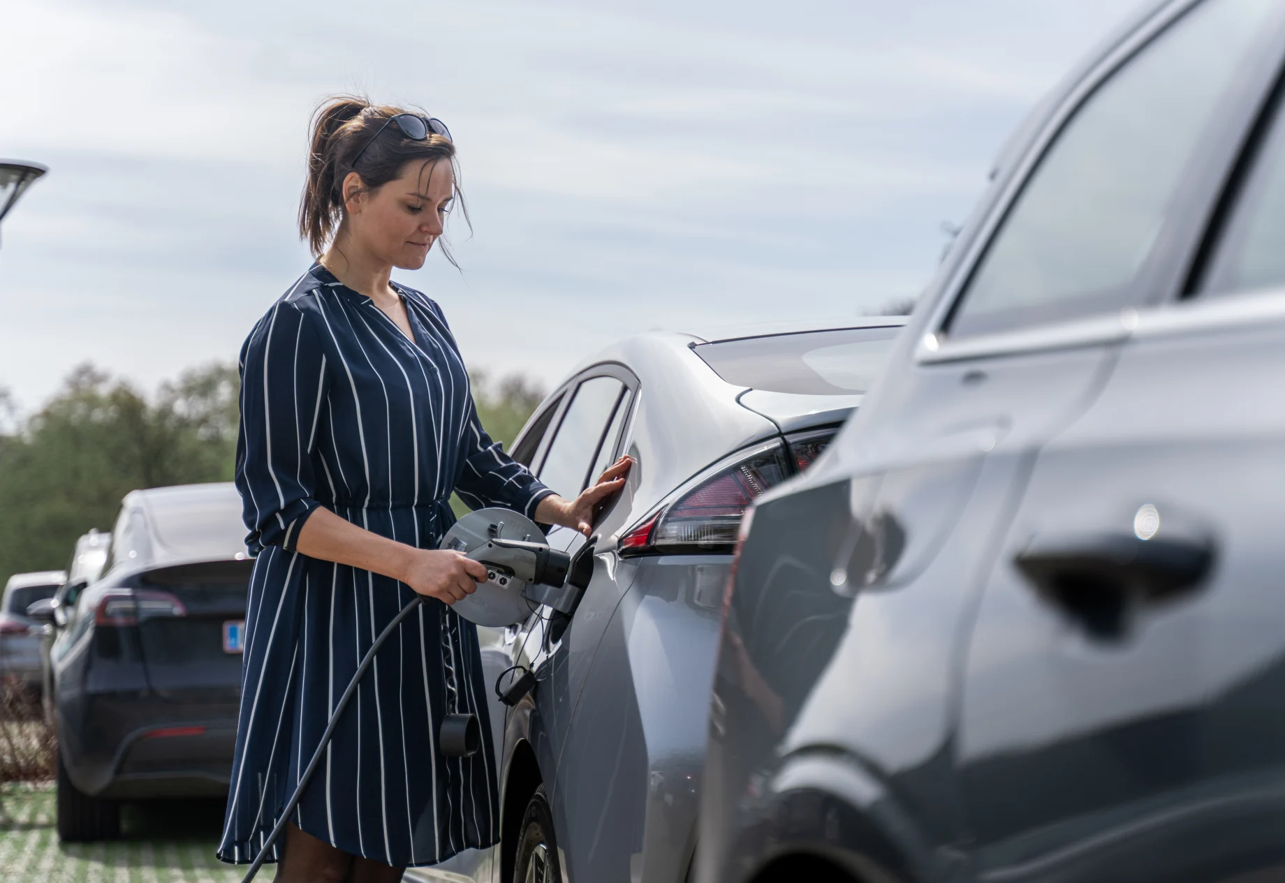 Kvinde som oplader sin elbil