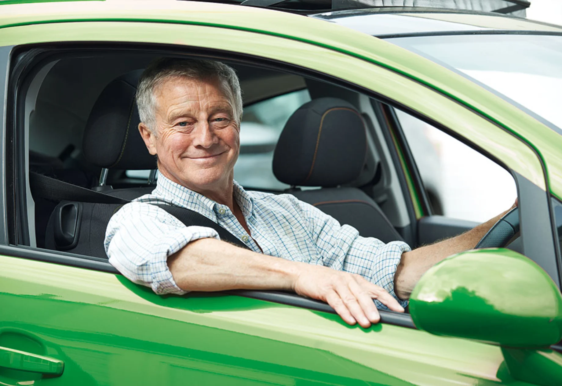 Ældre mand som sidder i en grøn bil
