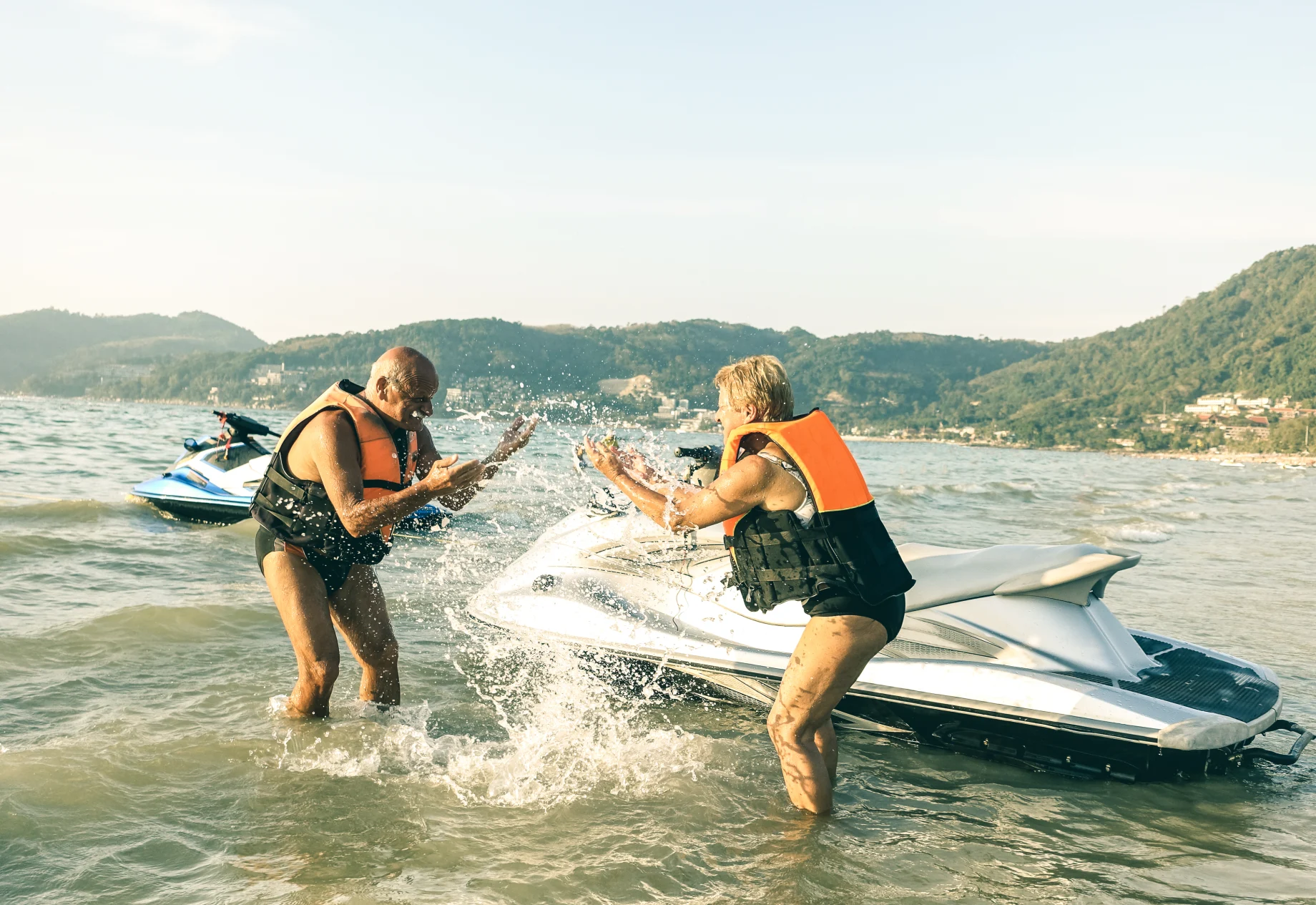 Ældre par som står på vandscooter