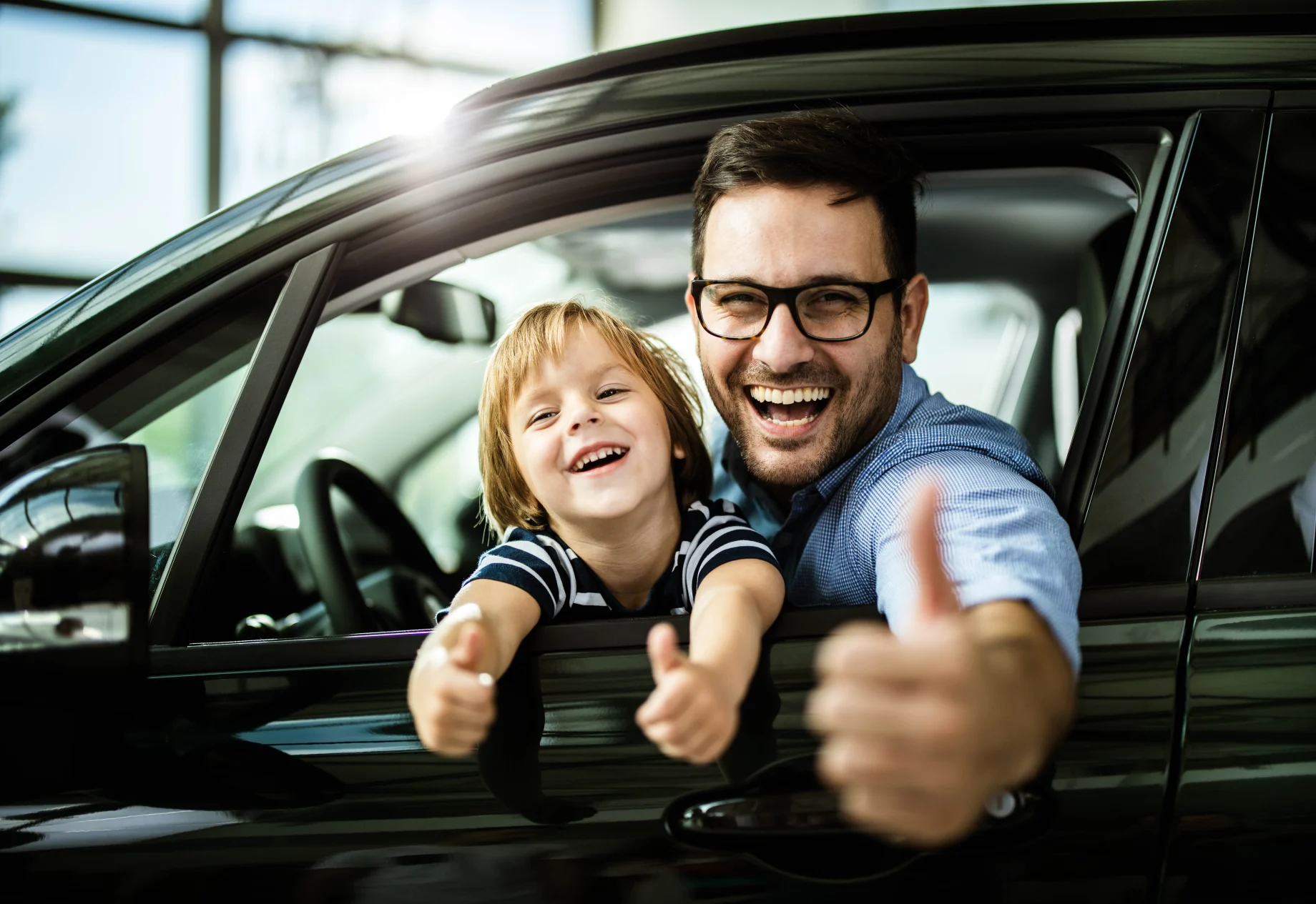 Bilforhandler far og søn på forsæde