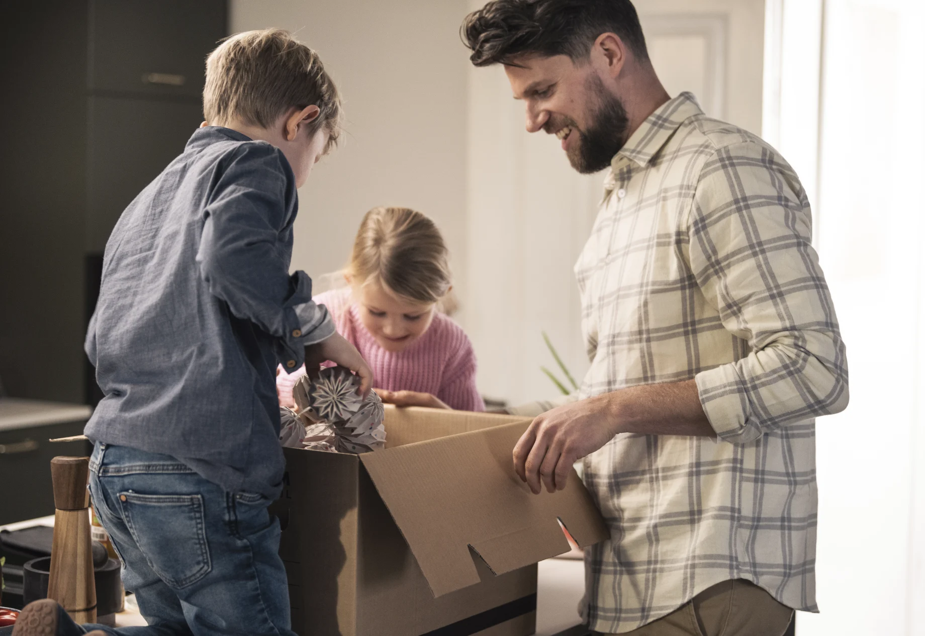 Familie som pakker ned i en flyttekasse