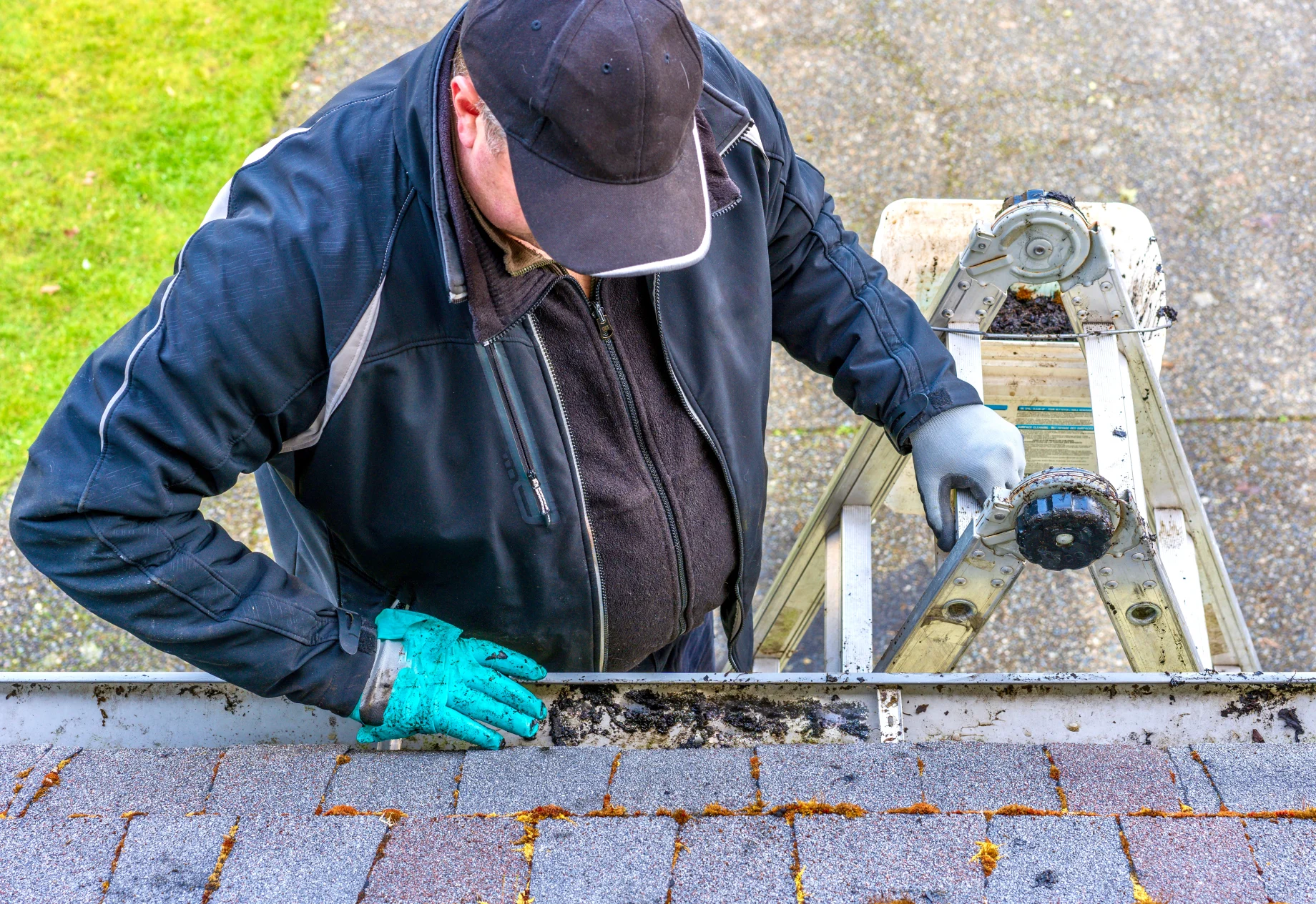 Mand på stige, oppe på tag