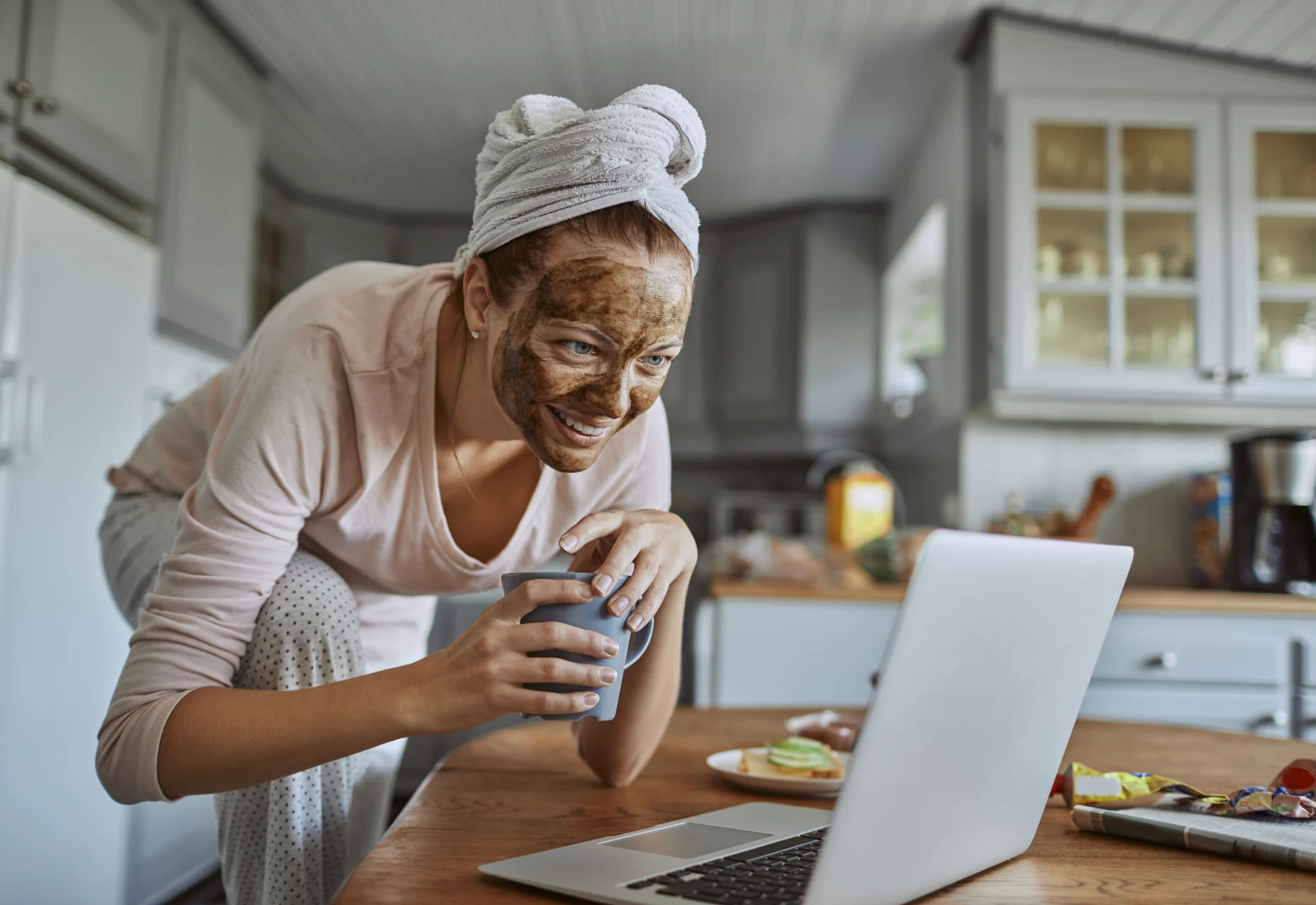 Kvinde med ansigtsmaske på ved computer