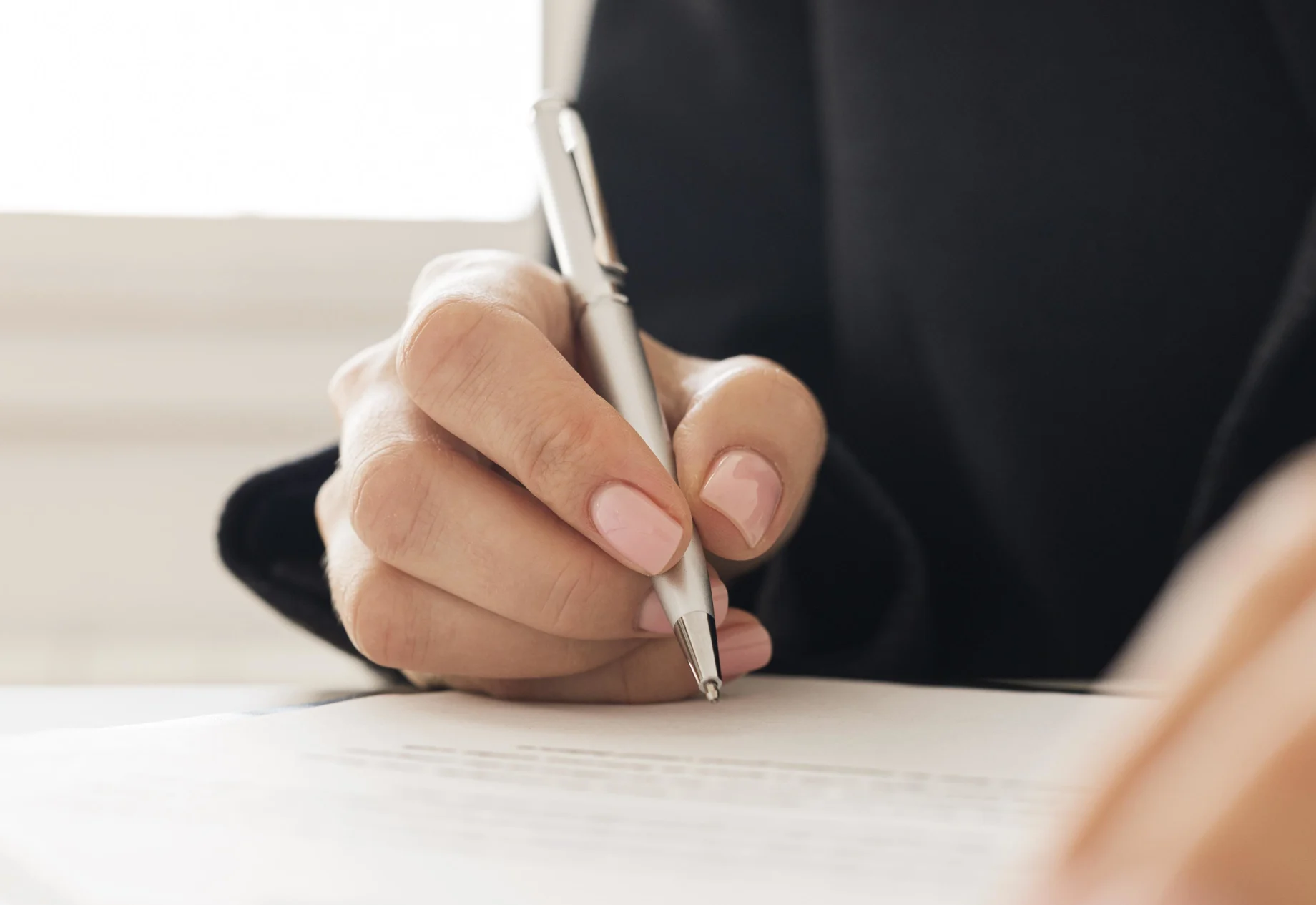 Skriver med kuglepen på papir