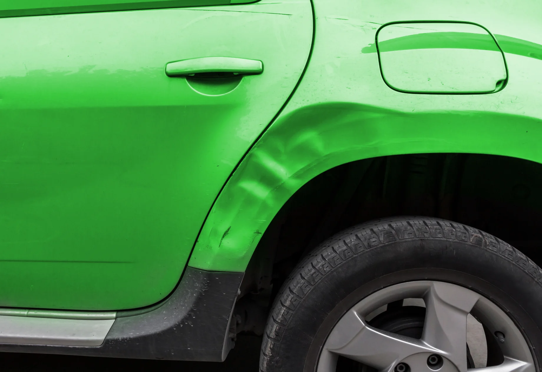 Grøn bil med en bule i siden