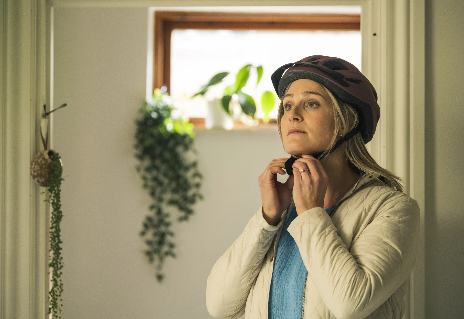 Kvinde som tager cykelhjelm på