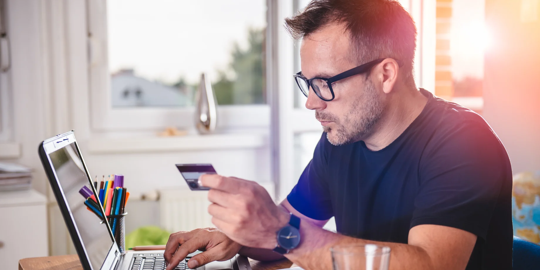 En mand som taster sine kort-oplysninger ind