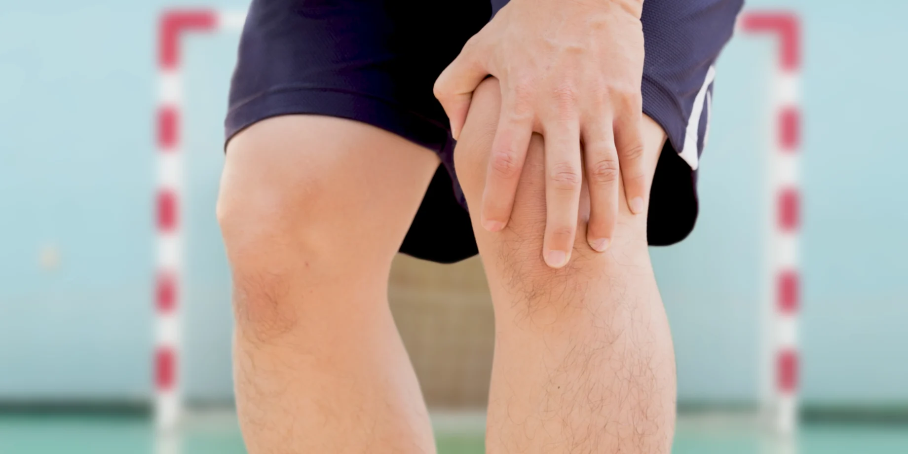 En hånd som holder på et knæ til håndbold