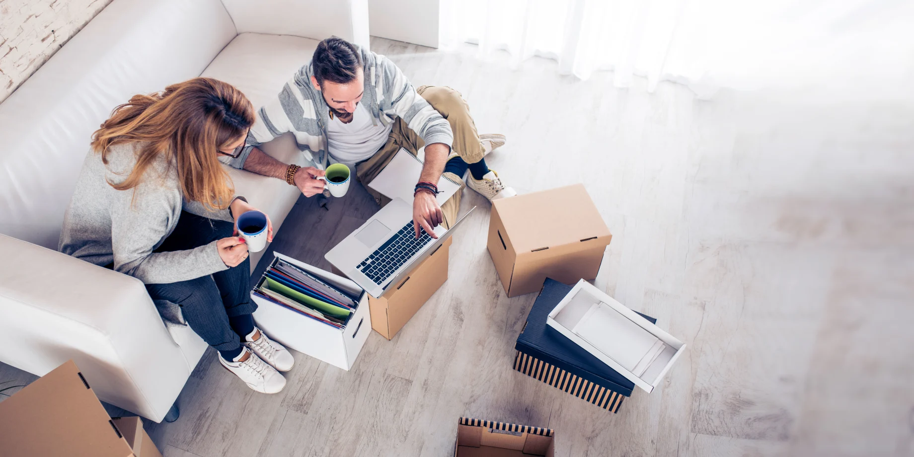 Par som sidder midt i en flytning og kigger på deres computer