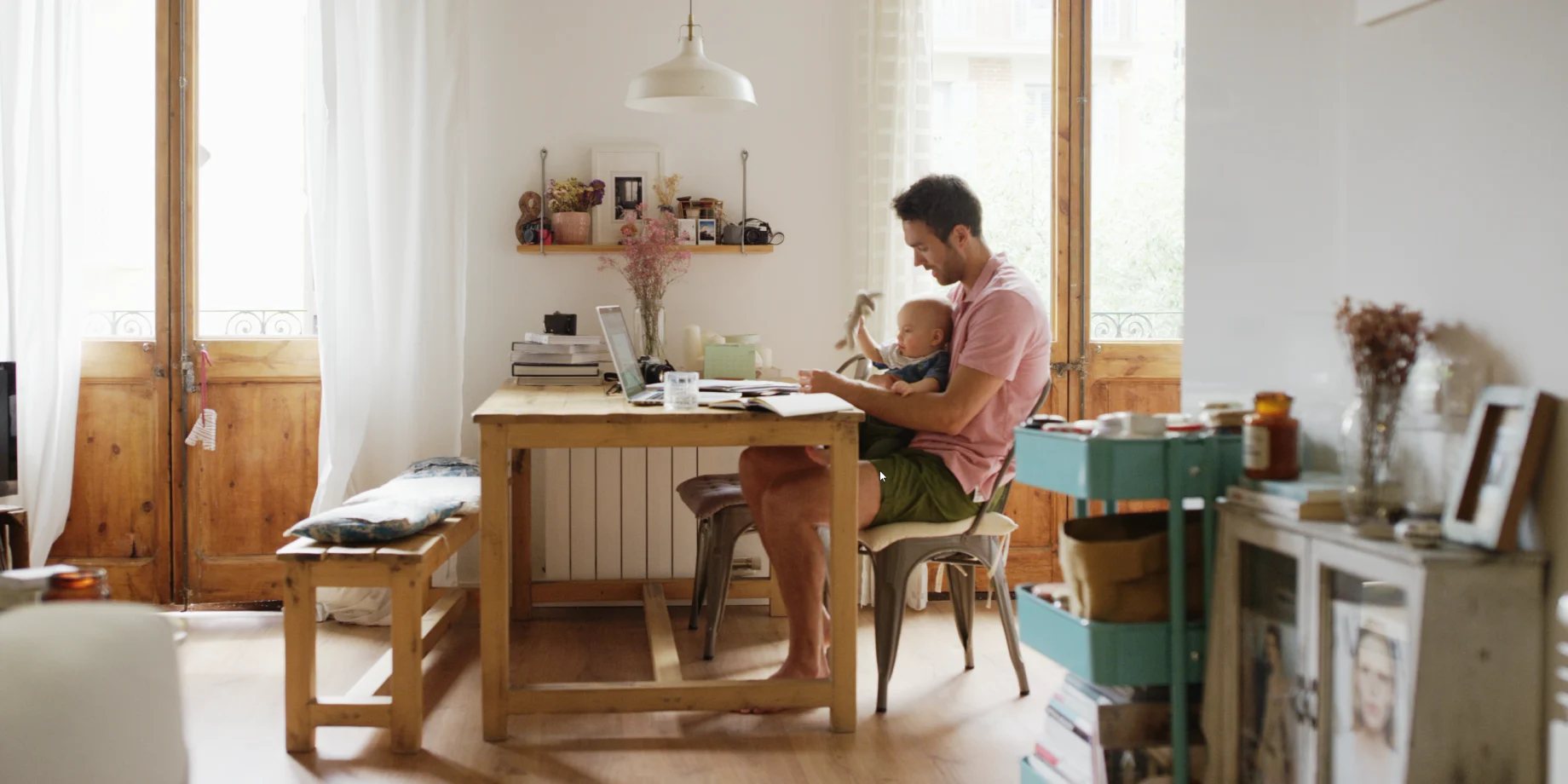 Mand som sidder med en baby ved spisebord