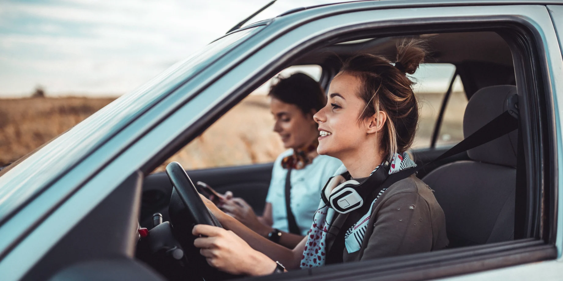 To unge piger som sidder i bilen