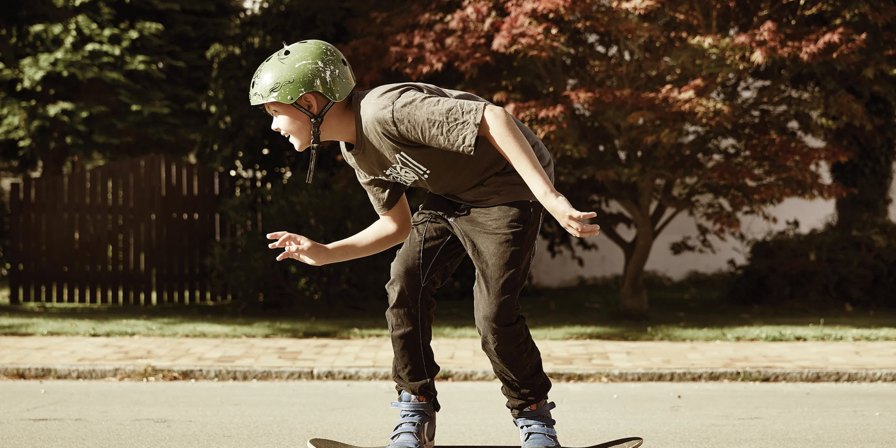 Ung dreng står på skateboard