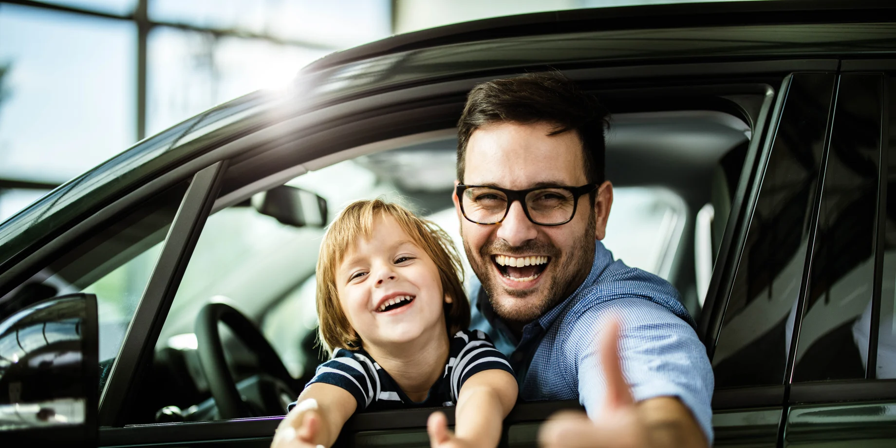 Bilforhandler far og søn på forsæde