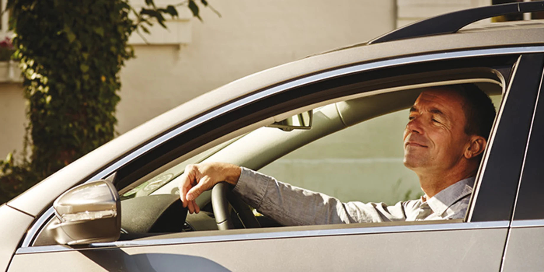 Mand som kigger ud af vinduet i sin bil