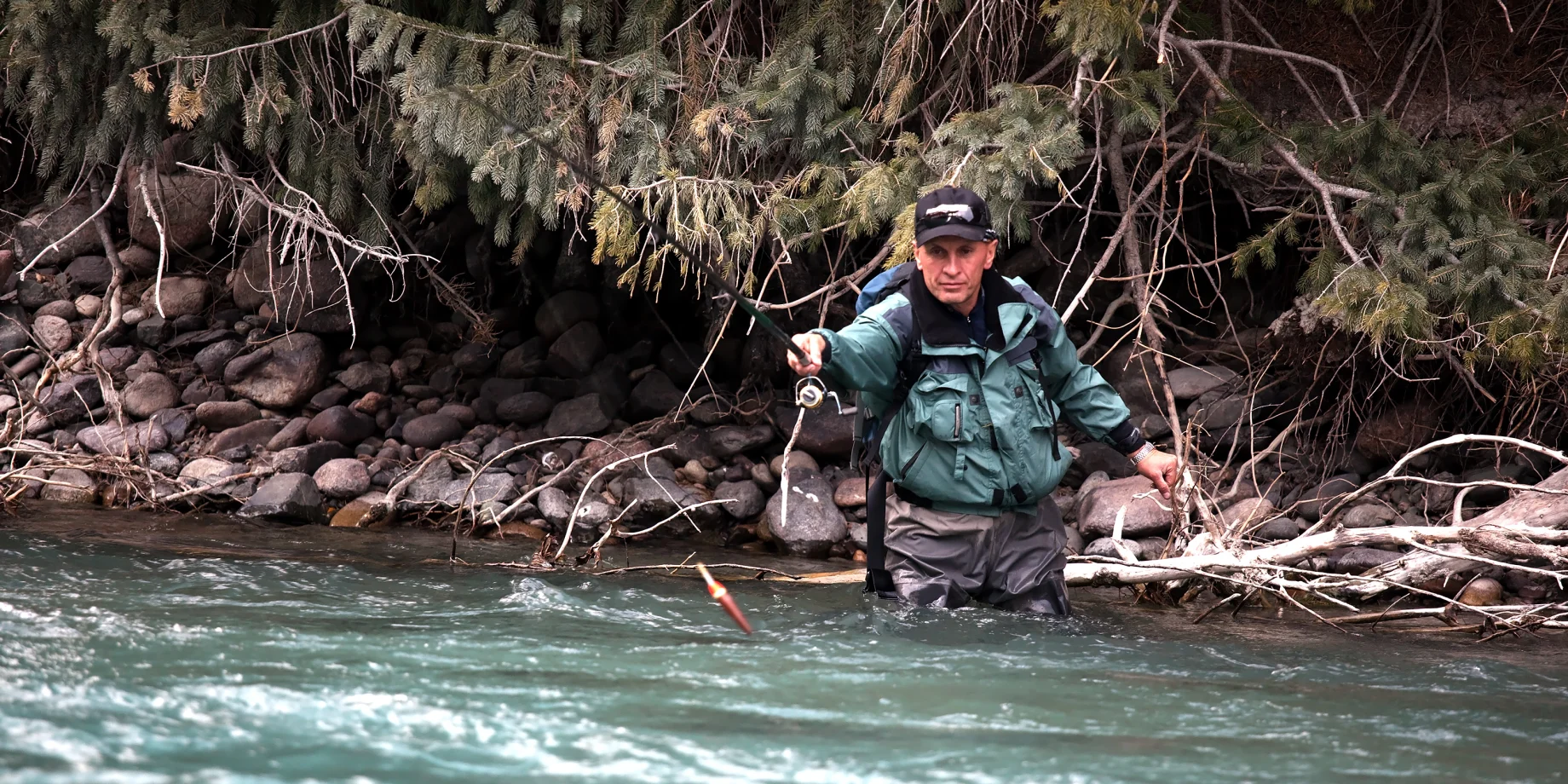 Mand som fisker i en flod