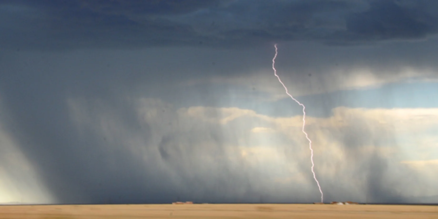 Mark med skybrud og et lyn