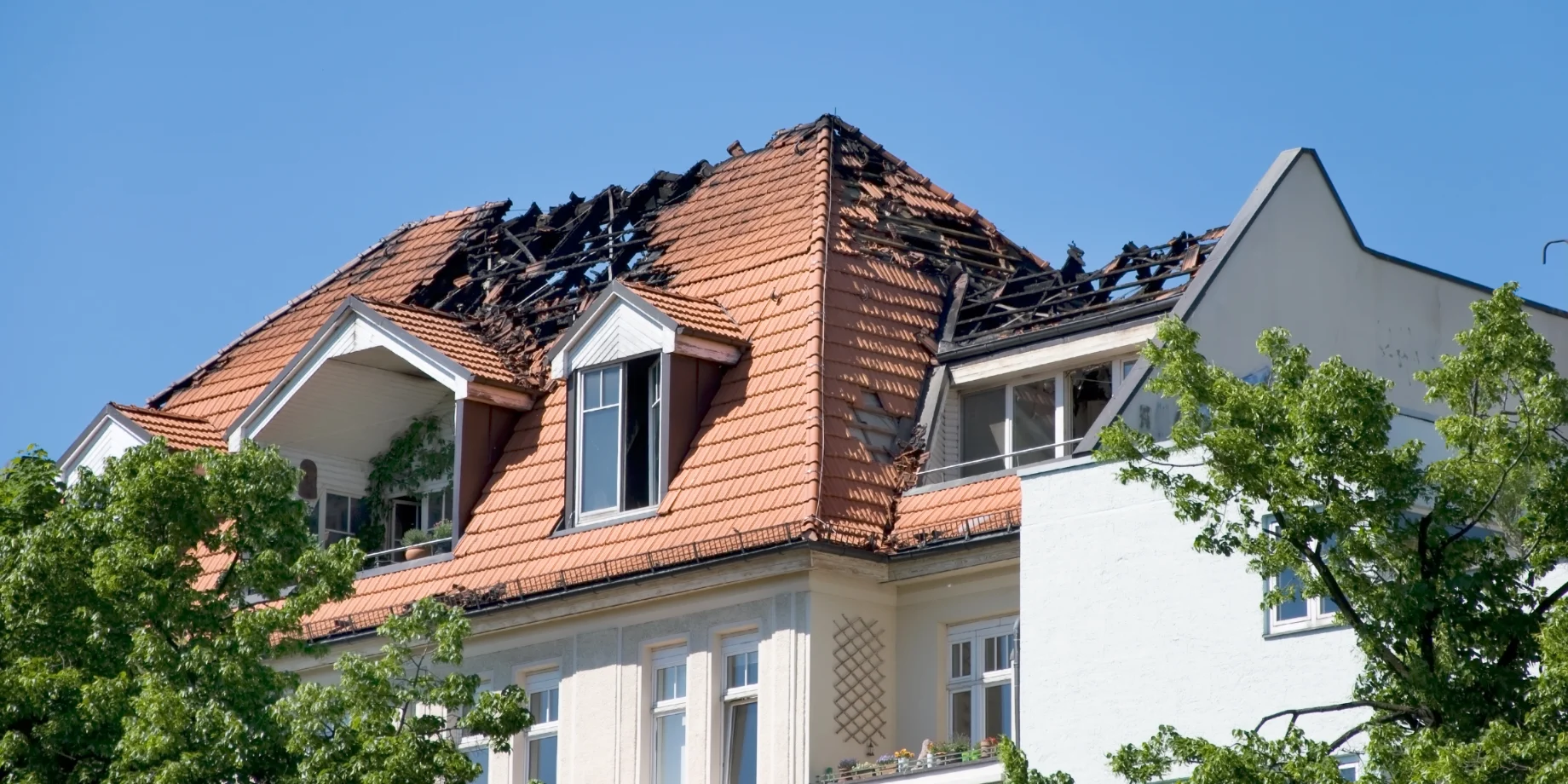 Hvidt hus med brandskade i taget